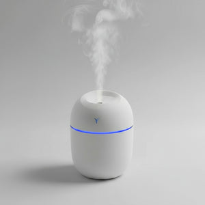 Three colorful humidifiers on a light surface with a light blue background