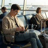 Black compact mirror with USB cable, charging adapter, and other electronic accessories on a white background