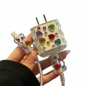 Colorful gemstone-studded phone charger held by a hand