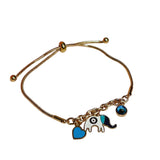 Gold bracelet with elephant and heart charms on a white surface