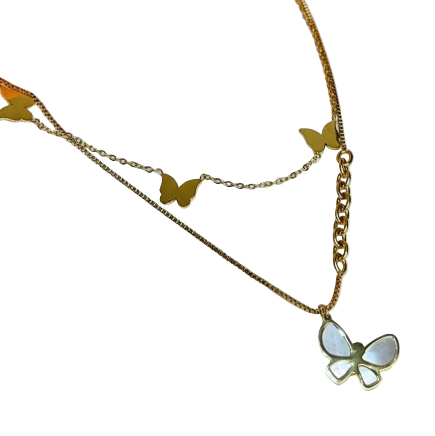 Gold butterfly necklace on a white background