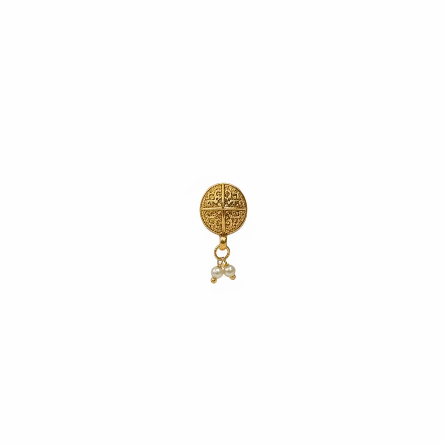 Gold earring on a black stand with a blurred background