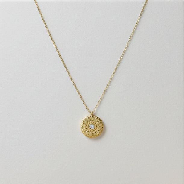 Gold necklace with a circular pendant 