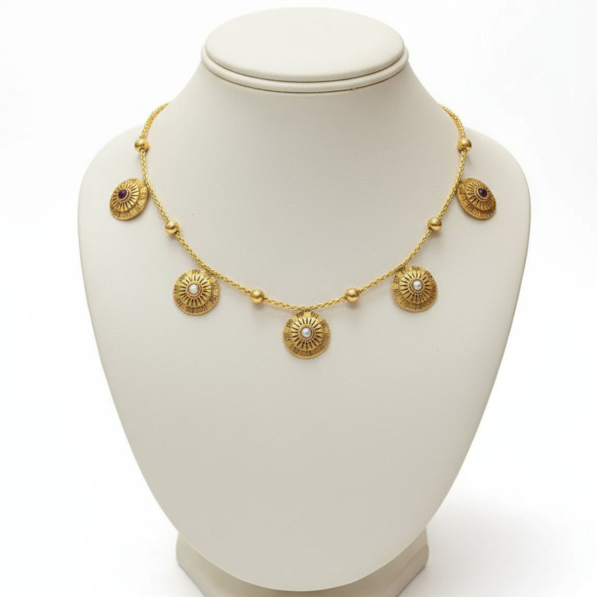 Gold necklace with circular pendants on a green mannequin bust.