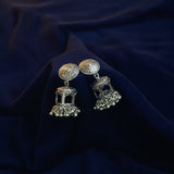 Pair of silver earrings on a black fabric background