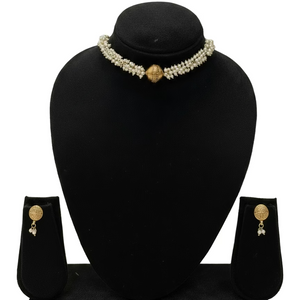 Pearl necklace and earrings set on a green mannequin bust with a plain background