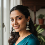 Silver earrings on a wooden surface with a natural background