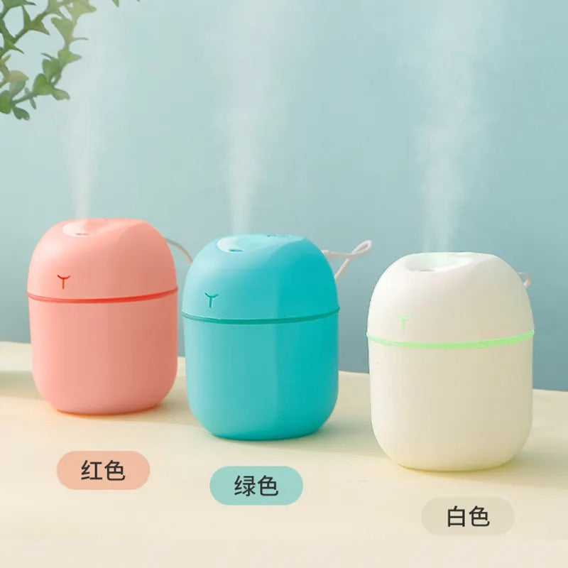 Three colorful humidifiers on a light surface with a light blue background